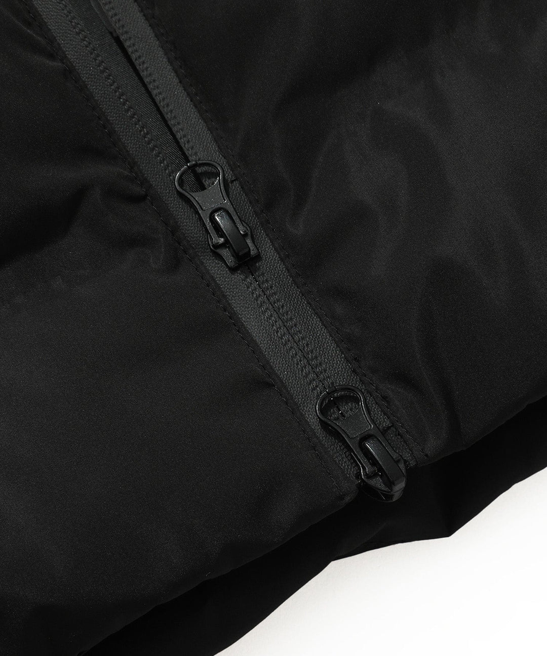 Detail of the warm hood with faux fur trim on a women's insulated black long parka coat.