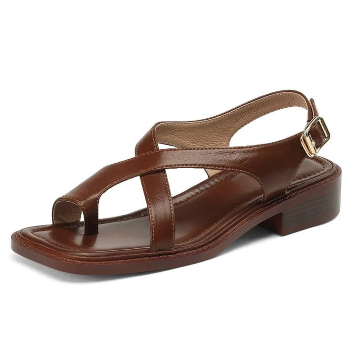 Women's white leather flat sandals with decorative cross straps, emphasizing comfort