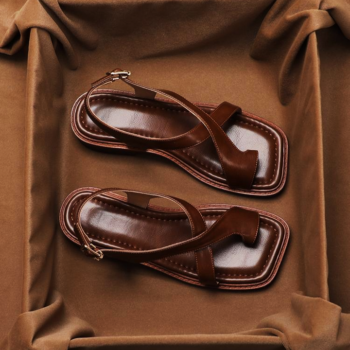 Brown leather comfort sandals for women featuring elegant cross straps and a flat sole