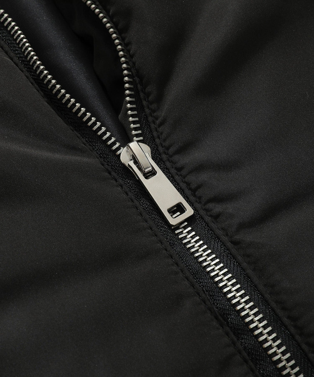 Back view of a women's black quilted puffer vest with a well-fitted hood, winter fashion