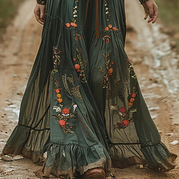 Woman wearing a graceful long sleeve embroidered bohemian maxi dress. Flowing elegant design for any special occasion.