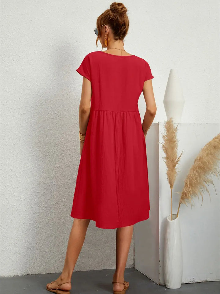 Loose fit women's midi dress with pockets, comfortable short sleeve design for spring and summer fashion.