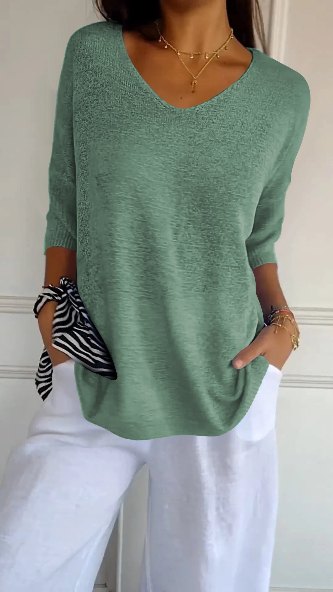 Stylish women's V-neck top with three-quarter sleeves, perfect for casual everyday wear.