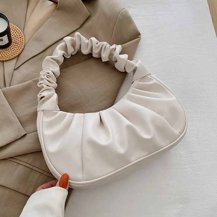 Woman carrying a white pleated cloud shoulder bag, perfect fashion accessory for daily use