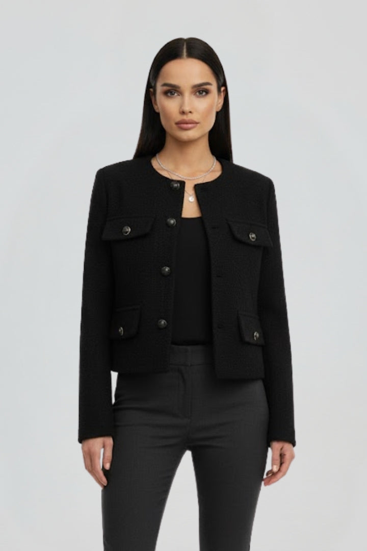 Close-up of a women's chic cropped jacket with visible button-front and chest pockets, versatile outerwear.