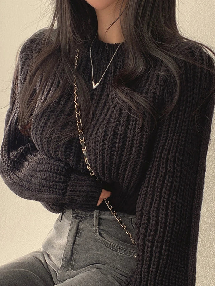 Relaxed fit women's chunky knit sweater featuring elegant lantern sleeves and ribbed details, side view