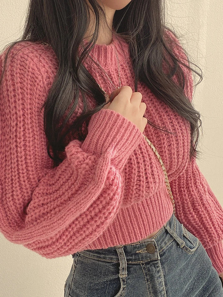 Ribbed hem and cuffs of a women's chunky knit lantern sleeve sweater, adding a touch of sophistication