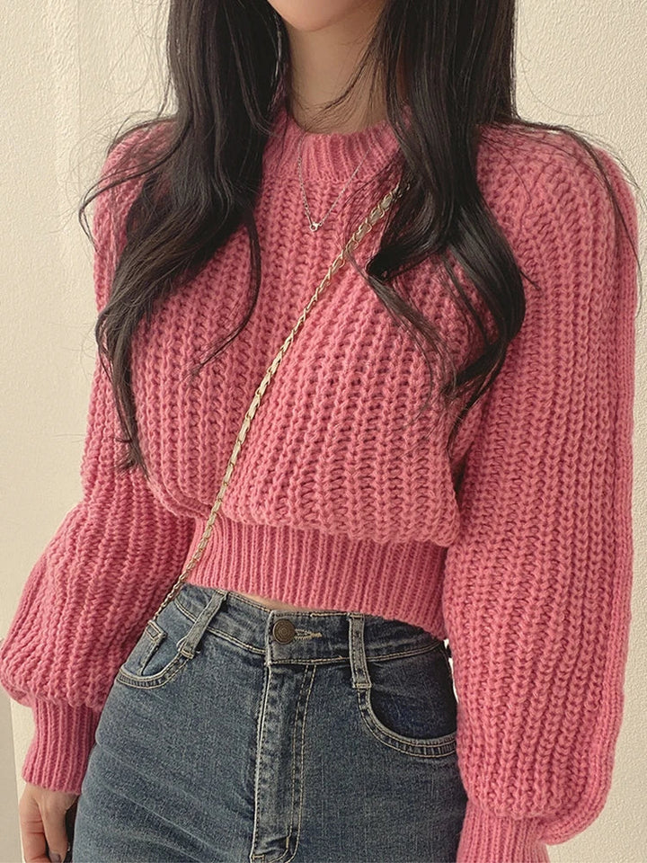 Studio shot of a women's chunky knit lantern sleeve sweater, emphasizing its comfy and trendy appeal