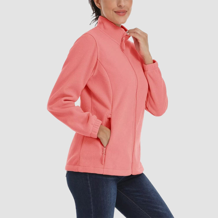 Full body shot of a woman in jeans and a mustard yellow full-zip fleece jacket, everyday style