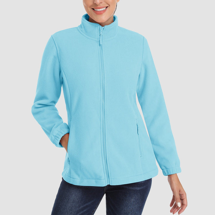 Woman hiking in a deep blue full-zip fleece jacket, showing its functionality as warm outerwear