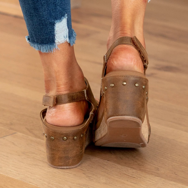 Woman walking in comfortable wedge sandals. Supportive, elegant slip-on espadrille style for fashionable summer wear.