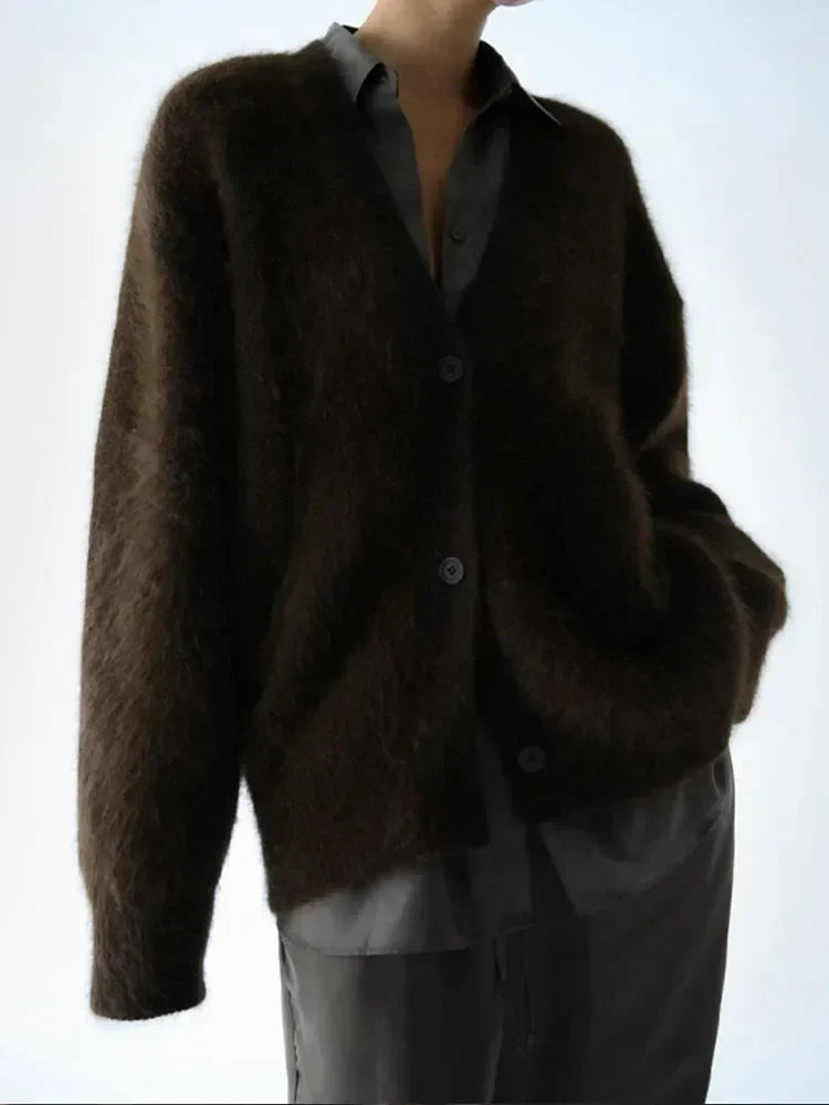 A stack of colorful women's oversized cardigans, emphasizing variety and soft knit