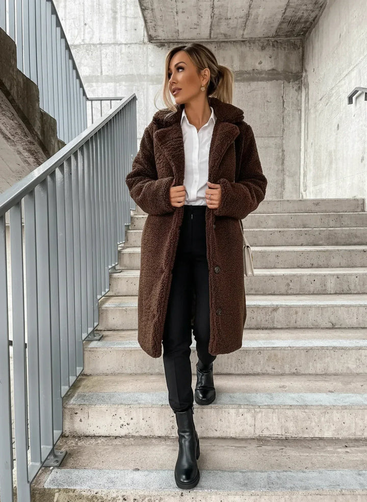 Fashionable women's long teddy coat, featuring a button-front and relaxed fit for comfortable winter wear.