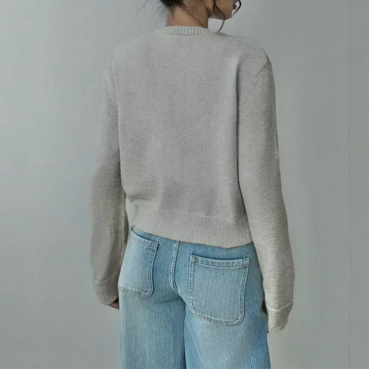 Side view of a woman in a navy cropped button cardigan, demonstrating its versatile design.