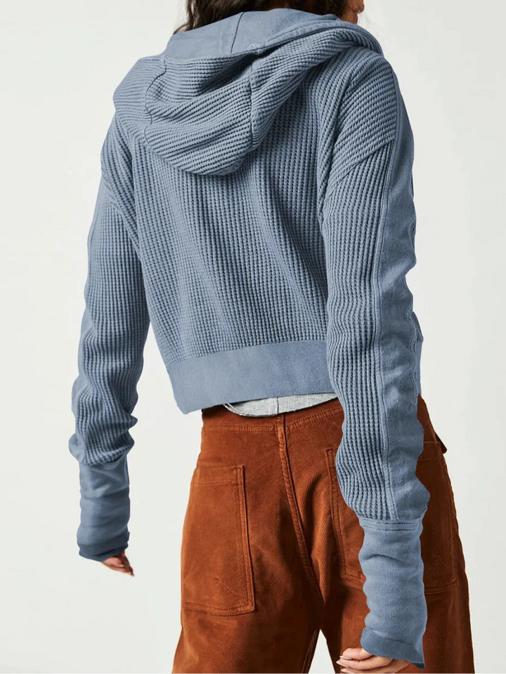 Fashionable women's cropped waffle-knit zip hoodie, styled with high-waisted pants