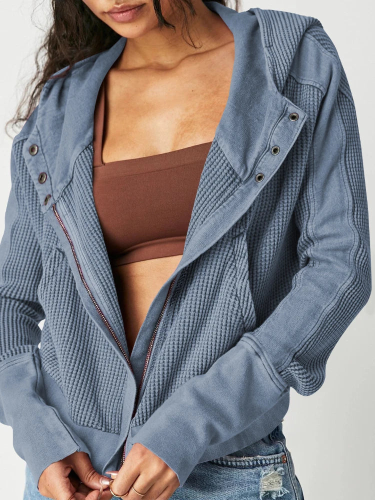 Close-up of waffle knit texture on women's cropped zip hoodie, soft cotton fabric