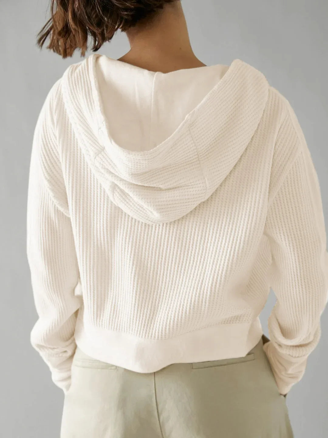 Close-up of the pull tab on the zipper of a women's cropped waffle-knit hoodie
