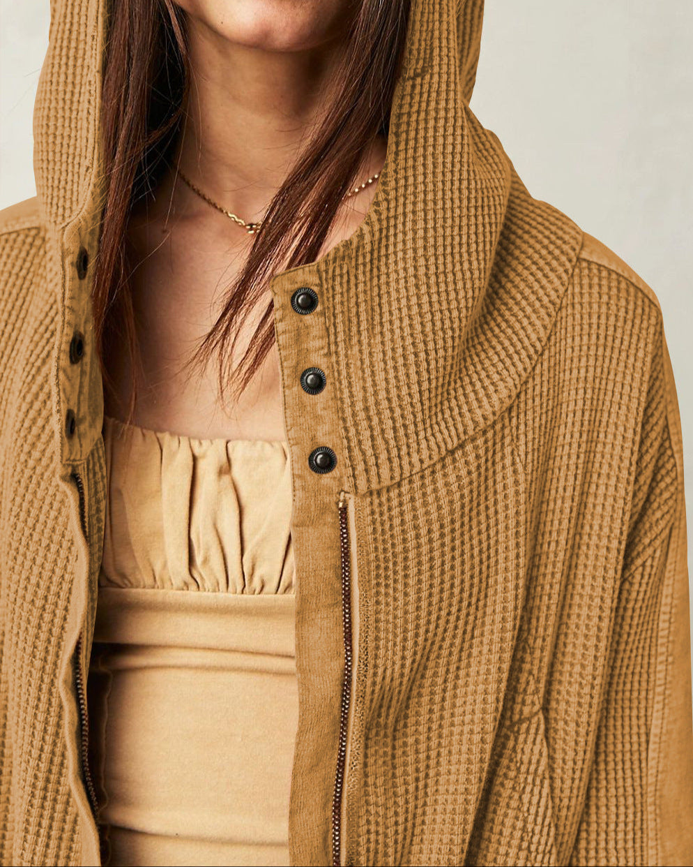 Detail of the shoulder seam on a women's cropped waffle-knit zip hoodie, quality build