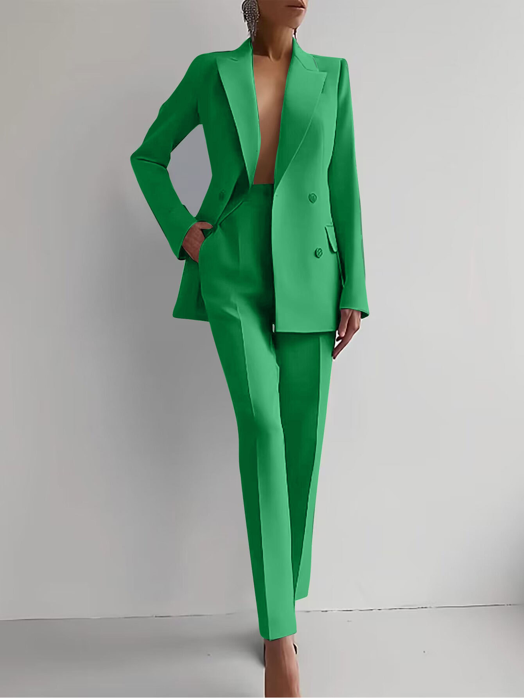 Elegant women's double-breasted blazer and slim trousers suit set. Stylish tailored professional attire.