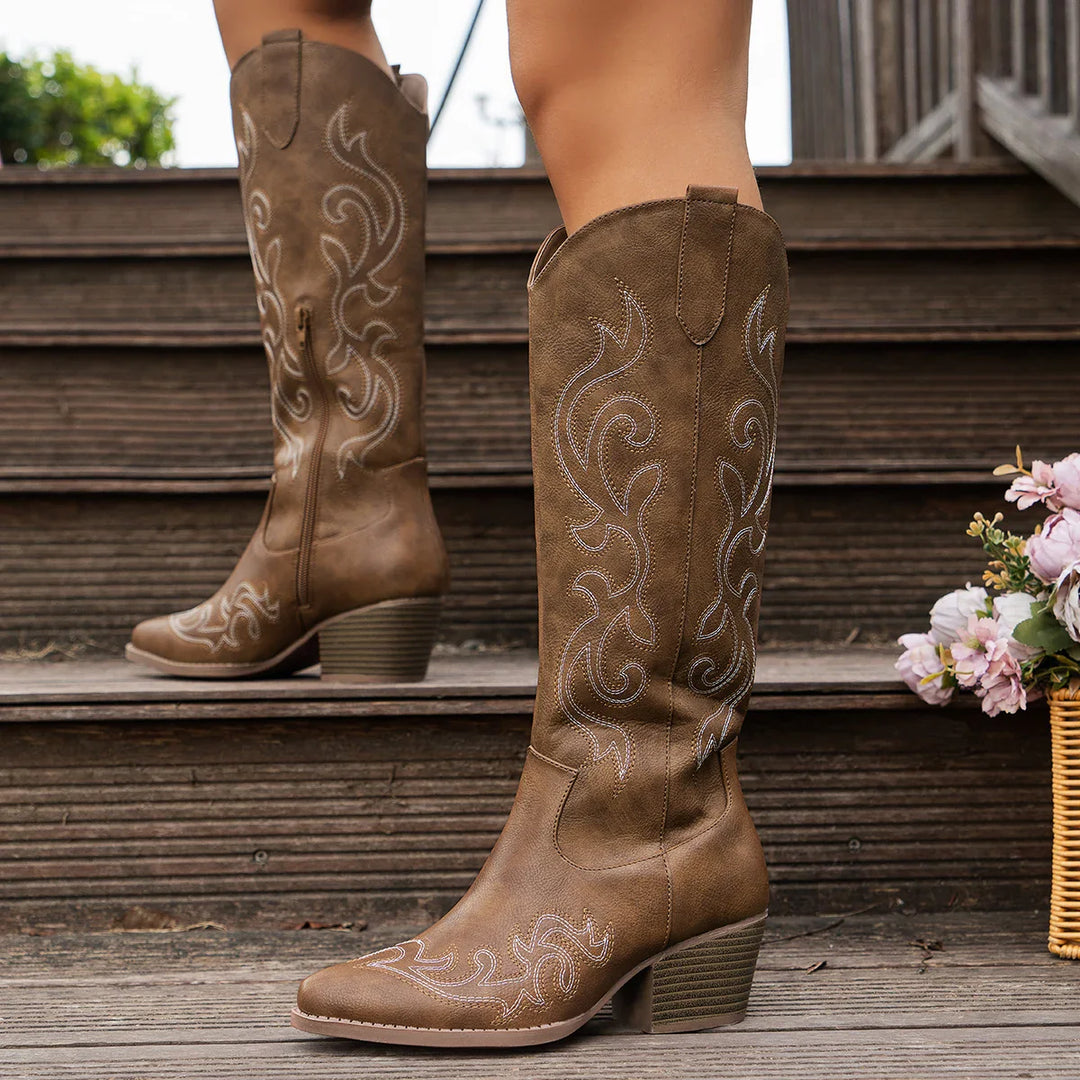 Close-up of the pointed toe and block heel on women's embroidered Western ankle boots, highlighting texture