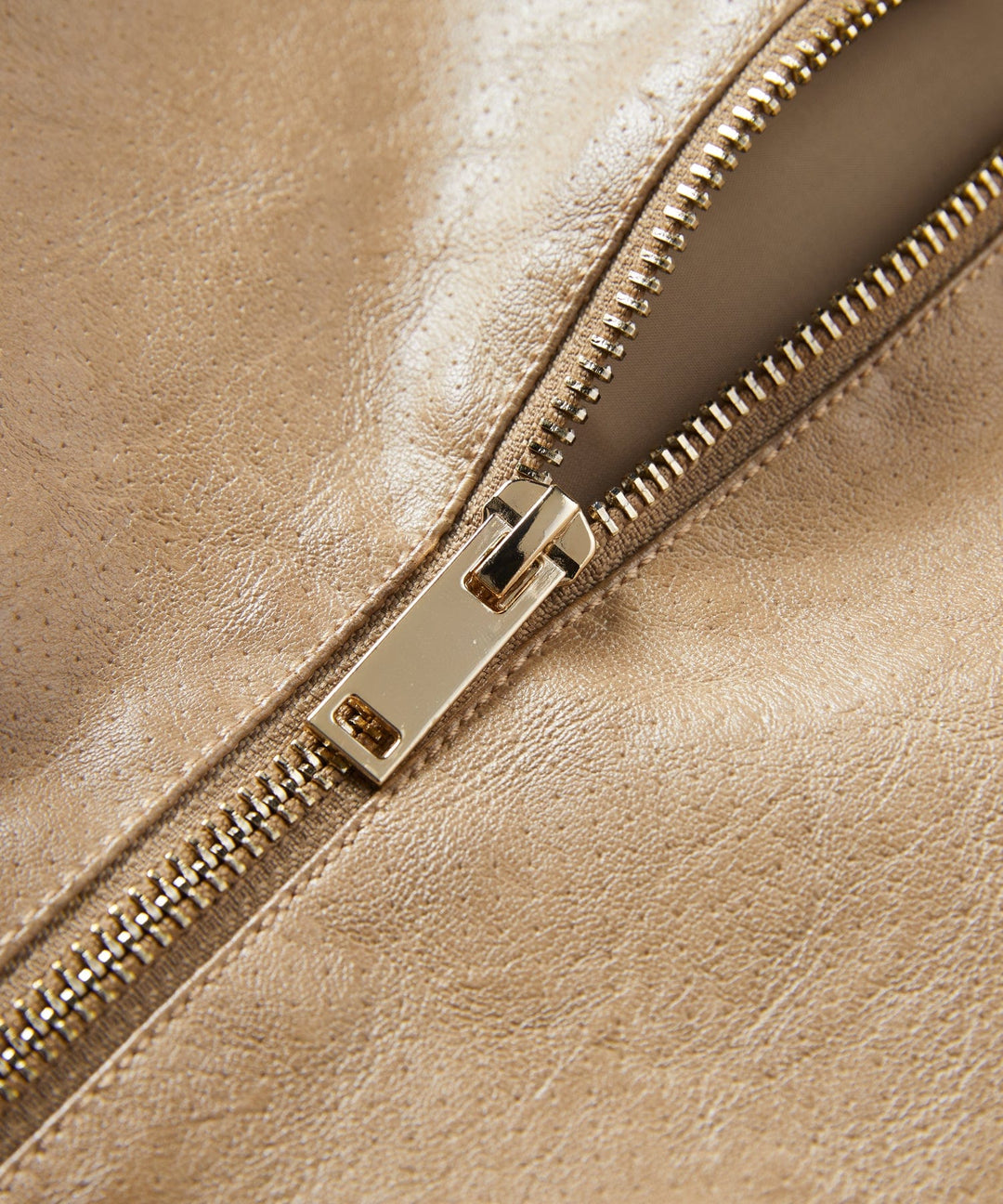 Close-up of the textured faux leather on a women's tailored jacket, suitable for both day and evening wear.