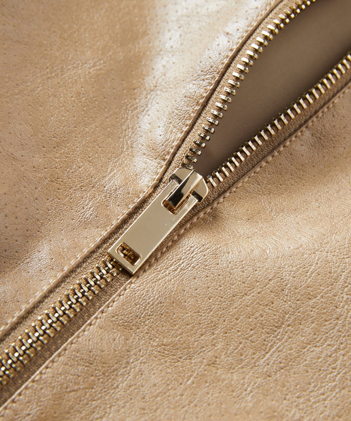 Close-up of the textured faux leather on a women's tailored jacket, suitable for both day and evening wear.