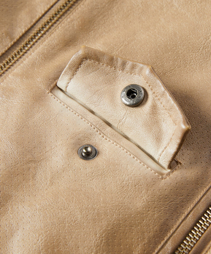 Detail shot of the sleeve and cuff of a women's faux leather jacket, exuding classic and modern style.