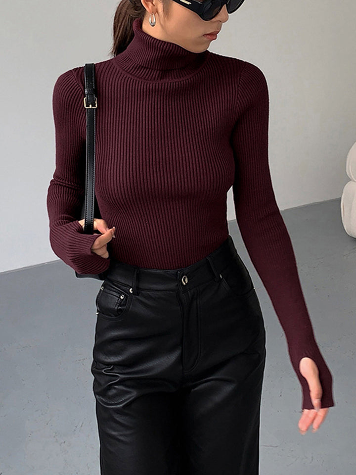 Model wearing a stylish gray ribbed knit turtleneck top, showcasing its elegant fit and long sleeves.