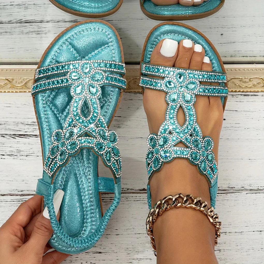 Stylish women's flat sandals with intricate floral accents, a must-have for summer outfits.