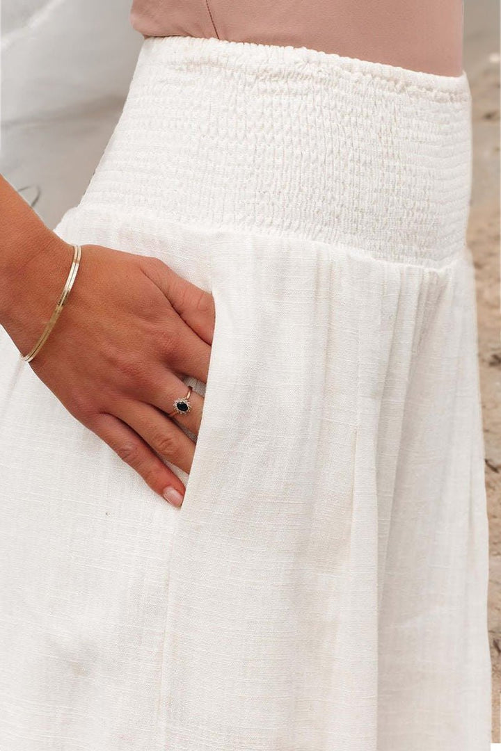 Relaxed fit women's flowing linen pants featuring a high smocked waist and stylish wide leg.