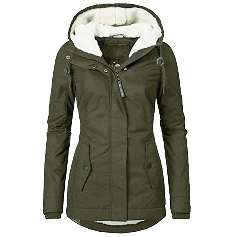 Fashion shot of woman wearing a stylish insulated fur-lined winter parka in urban setting.