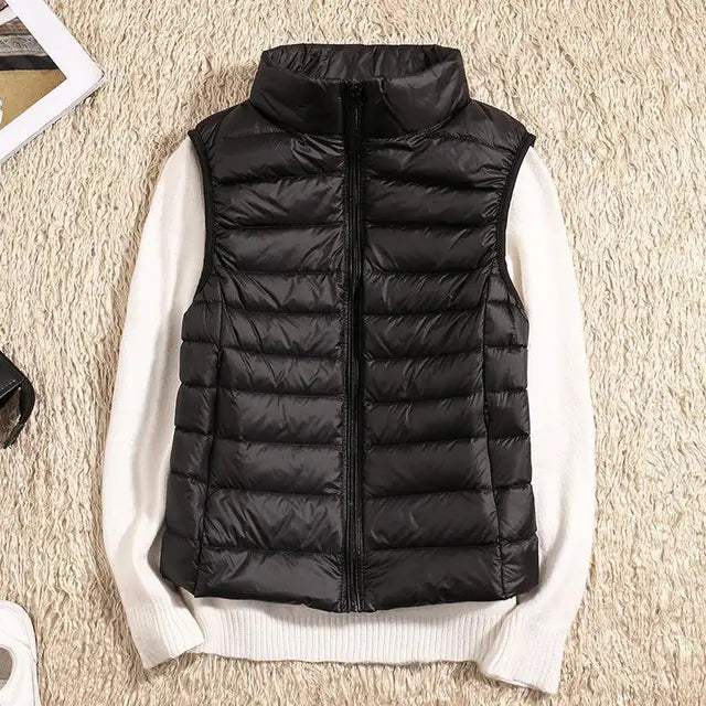 Front view of a white women's puffer vest, quilted and lightweight, with a protective high collar