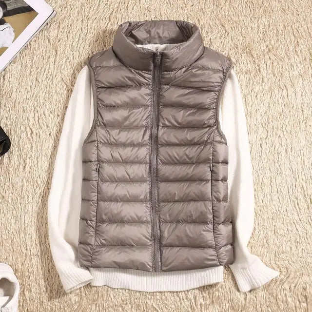 Outdoor shot of a woman wearing a blue quilted puffer vest with a high collar, ideal for casual layering