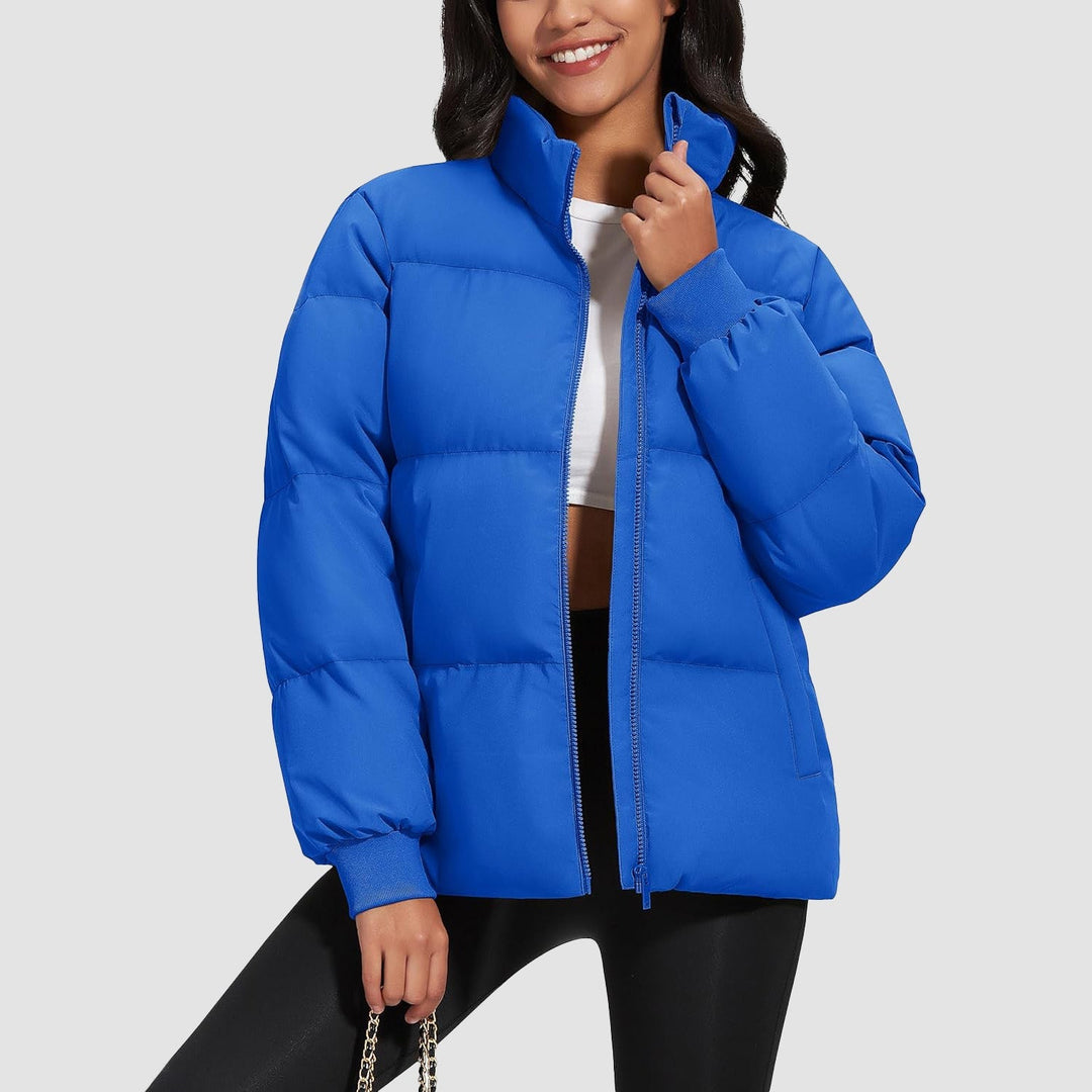 Woman smiling, wearing a black lightweight quilted puffer jacket, outdoors in winter