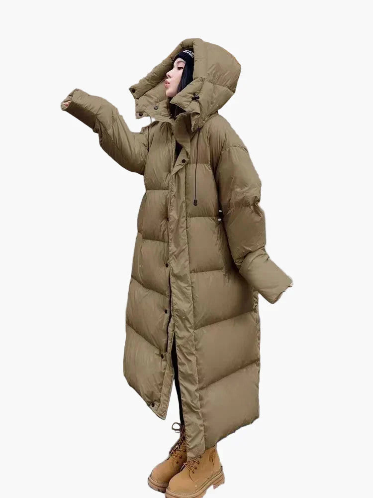 Stylish women's long quilted puffer jacket in a neutral color with hood, side view, warm outerwear