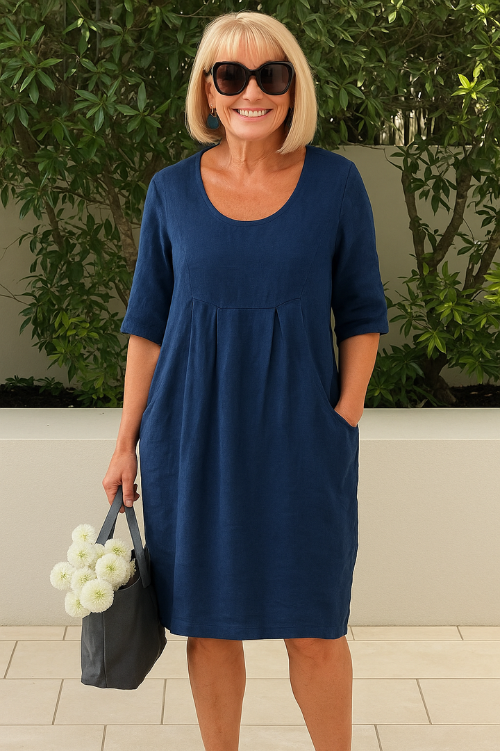 Chic women's pleated midi dress featuring a bust pocket, scoop neck, & short sleeves. Versatile A-line fit.