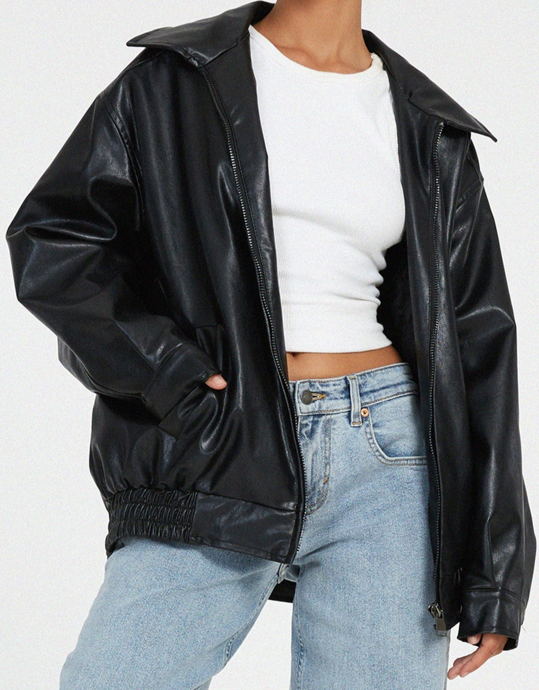 Detailed shot of the ribbed cuffs and hem on a women's oversized faux leather bomber jacket, brown color.