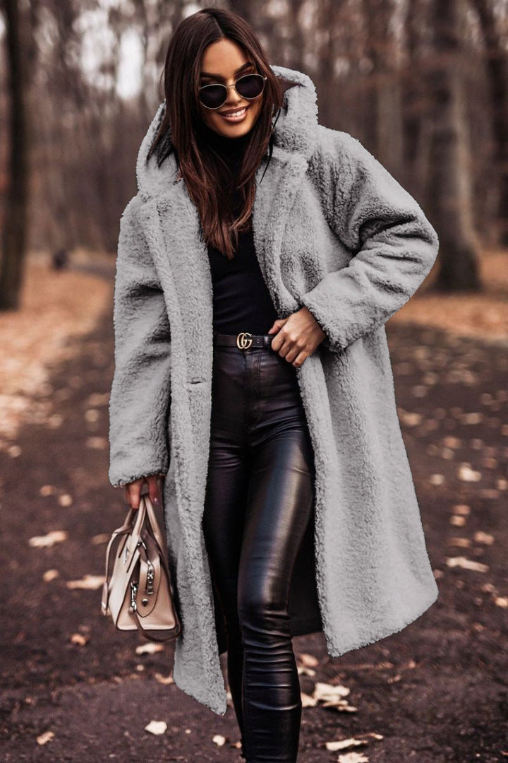 Side profile of women's long hooded faux shearling coat for fall/winter