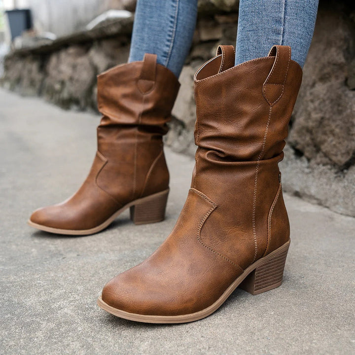Tan leather mid-calf boots for women, featuring classic cowboy boot design & comfortable fit.
