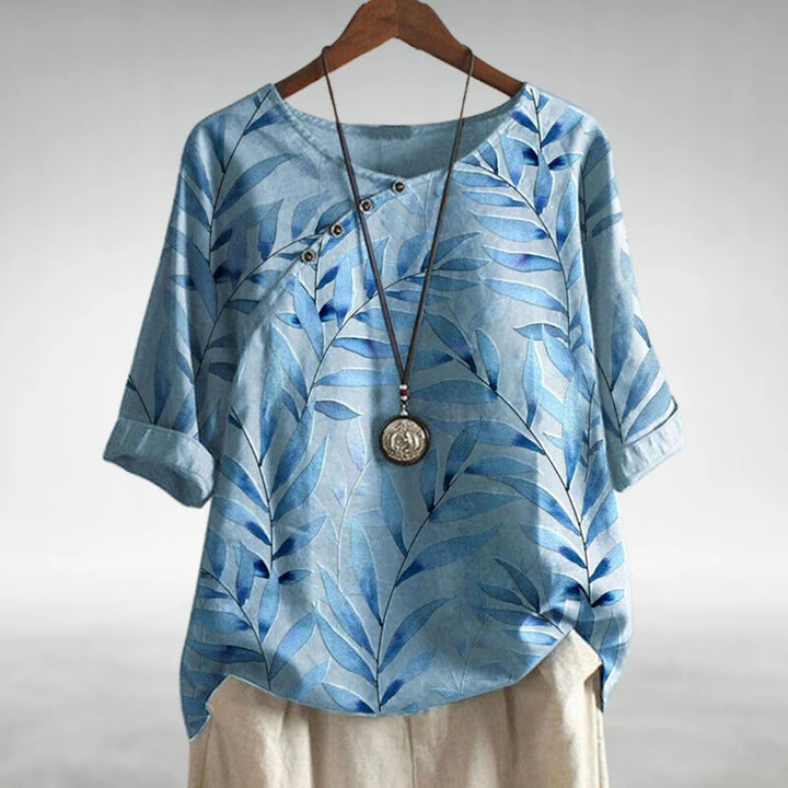 White women's printed blouse with unique asymmetric buttons, elegant for any occasion.