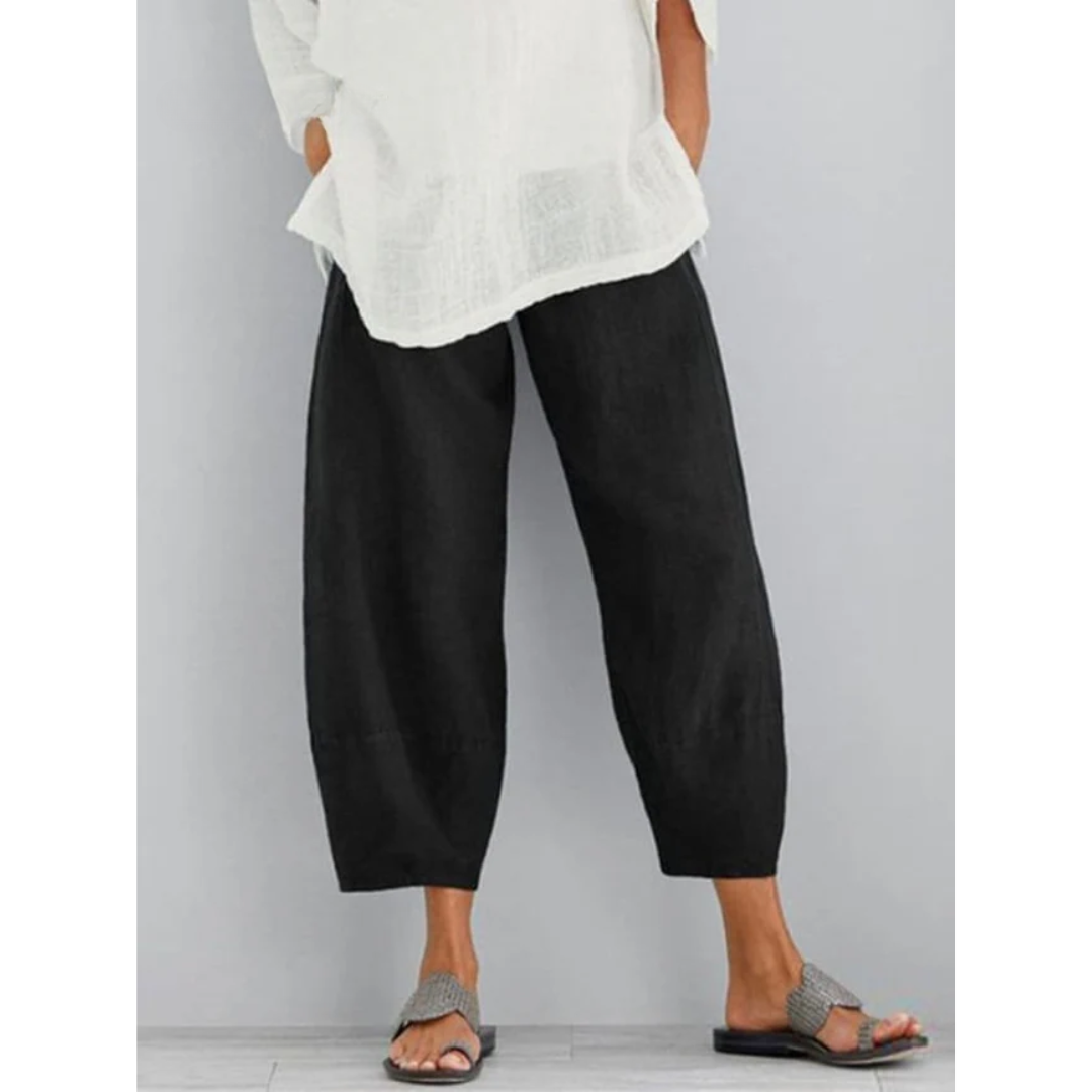Woman walking in relaxed fit linen leisure pants, showing comfort, flow & versatile style.