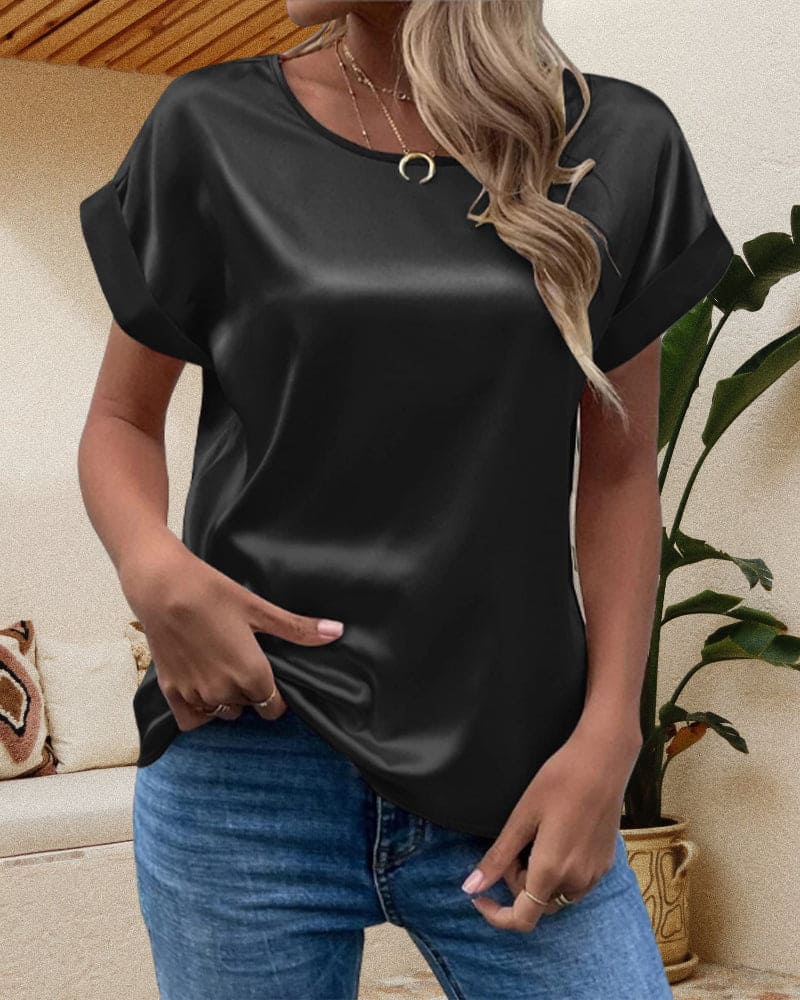 Folded image of a women's relaxed fit short sleeve satin blouse, showcasing its smooth fabric and design.