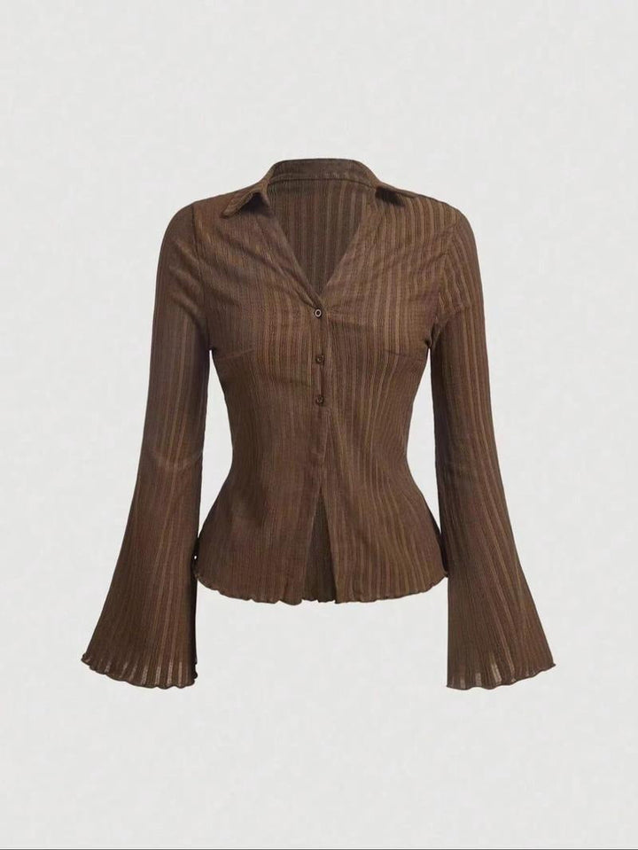 Detail of the flared sleeve and scalloped hem of a women's ribbed knit blouse. Soft, comfortable, and elegant design.