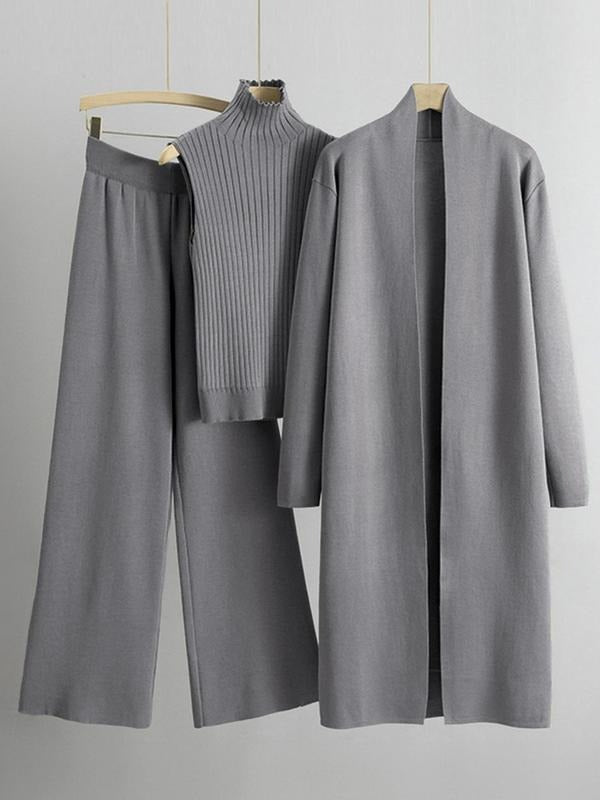 Full shot of a women's ribbed knit three-piece lounge set, highlighting the high neck top and wide leg pants