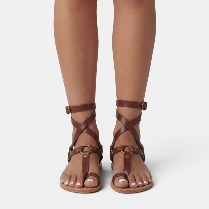 Stylish women's snake print flat sandals with buckled crossover straps for casual fashion.