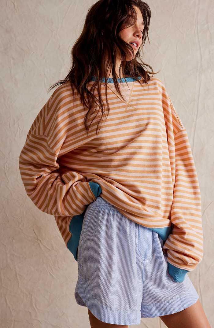 Full shot of a model wearing a comfortable women's striped crewneck sweater.