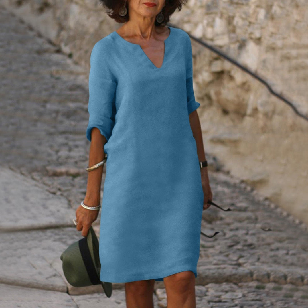 Woman enjoying summer in a comfortable, casual V-neck midi dress, perfect for warm weather.