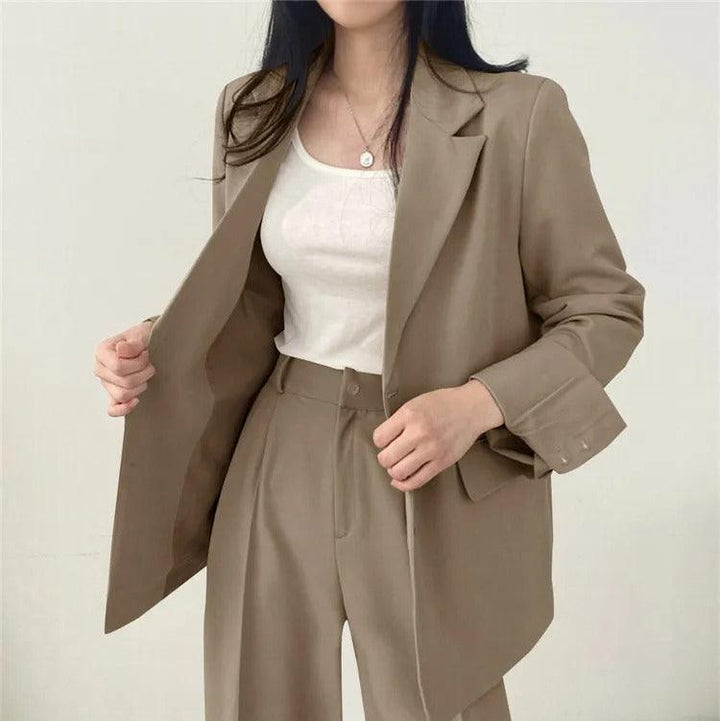 Chic women's tailored suit with a long blazer, embodying modern business casual elegance.