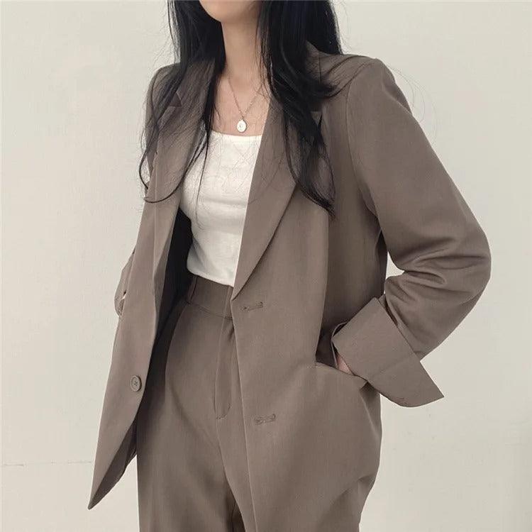 Practical women's workwear suit, including a long blazer and comfortable tailored trousers.