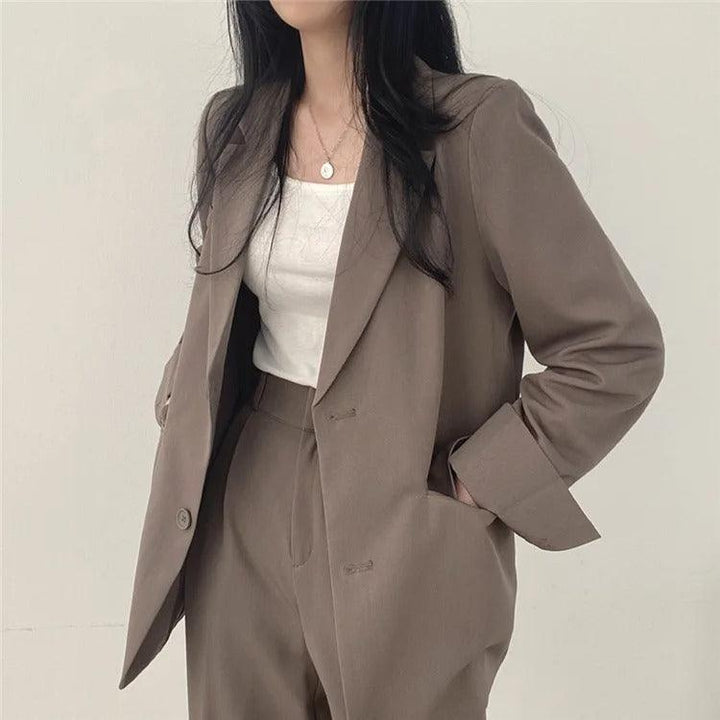 Practical women's workwear suit, including a long blazer and comfortable tailored trousers.